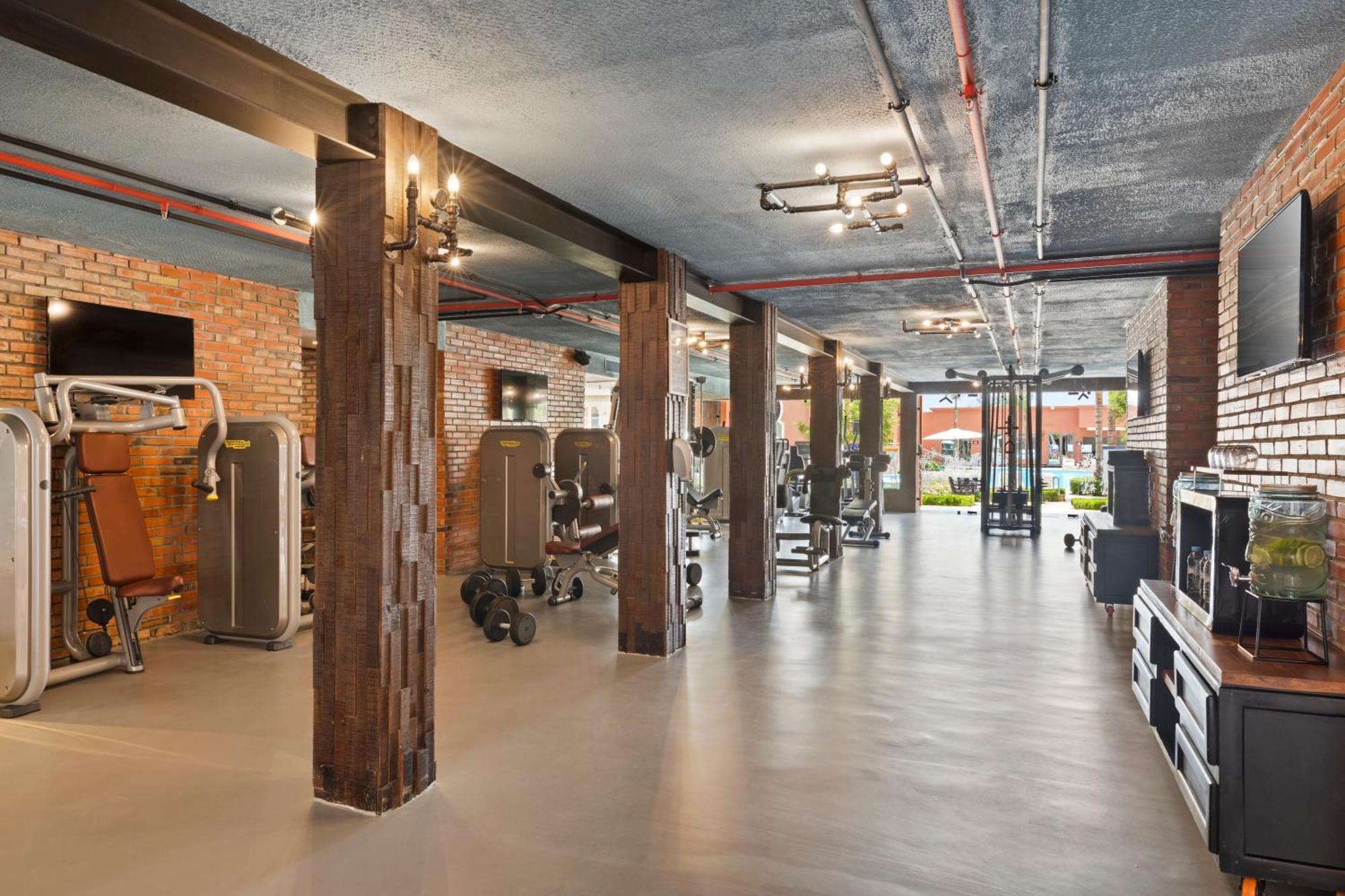 Savoy Le Grand Hotel Marrakech Marrakesh Exterior foto The photo shows a modern gym interior with a spacious layout. It features a polished concrete floor and exposed brick walls, giving it a contemporary yet industrial feel. There are various pieces of gym equipment, including weight machines and free w